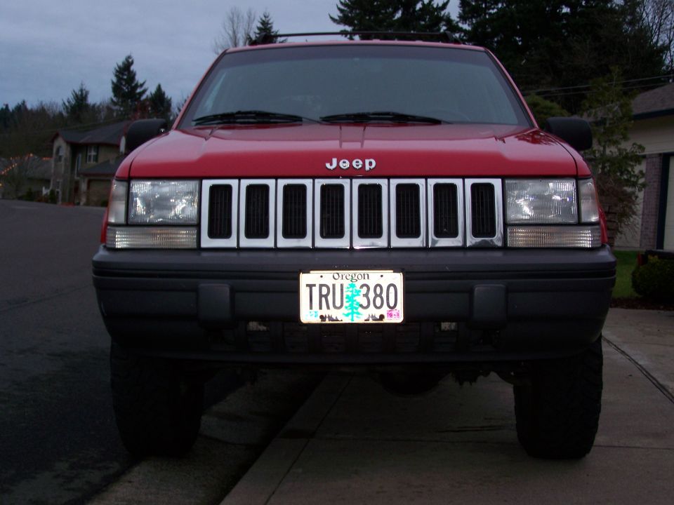 Front view of a red 1994 Jeep Grand Cherokee with a license plate that reads TRU 380