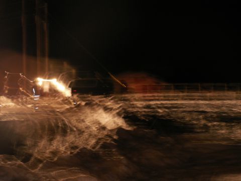 1984 Ford Bronco - A dark SUV is visible at night, its headlights cutting through the low visibility conditions.