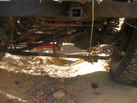 1992 Ford Mustang - Undercarriage view of a vehicle, showing suspension, drivetrain, and a tire on sandy terrain.