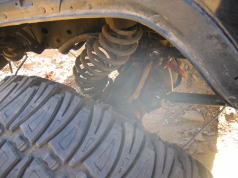 1992 Ford Mustang - A close-up view of the suspension system and a large tire, showing mechanical components and tread detail.