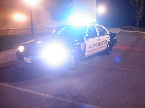2002 Ford Crown Victoria - A 2002 Ford Crown Victoria police car is parked at night with its emergency lights activated.