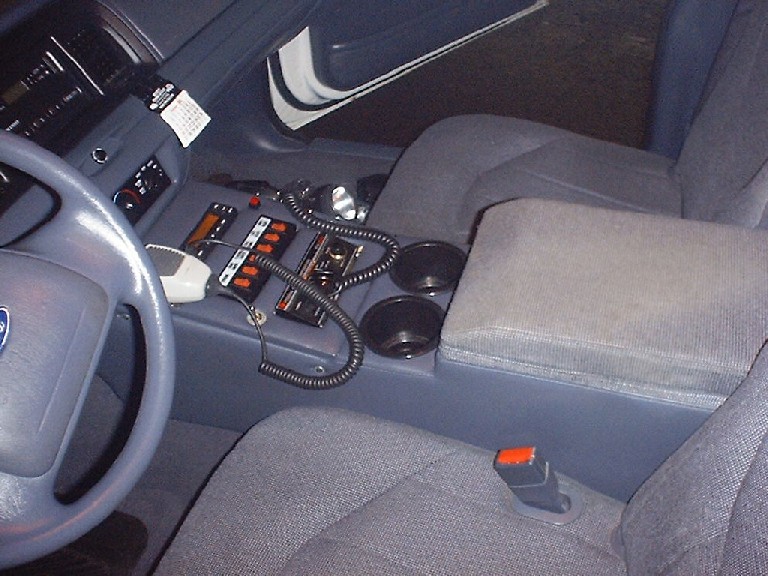 2002 Ford Crown Victoria interior showing center console with radio equipment, cup holders, and steering wheel