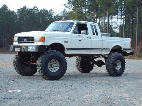 1990 Ford F-150 - This lifted 1990 Ford F-150 pickup truck features oversized off-road tires and a custom front bumper.