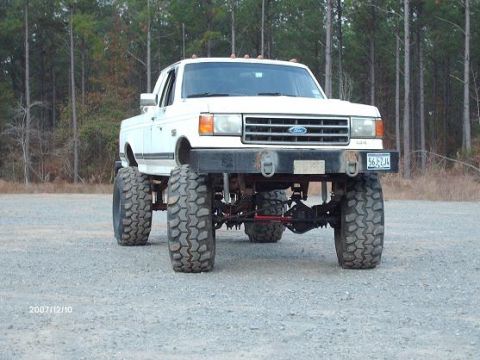 1990 Ford F-150 - This modified 1990 Ford F-150 features a significant lift kit and oversized off-road tires.