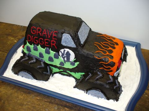 1978 Ford Bronco - A cake shaped like a monster truck, decorated with 'Grave Digger' and flame graphics.