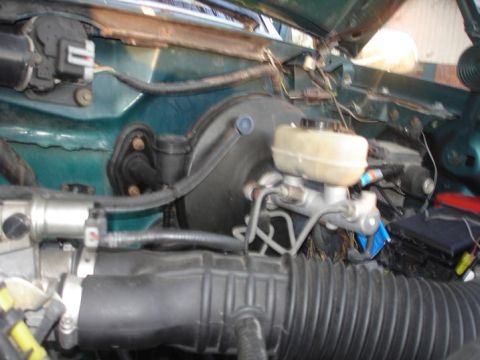 1996 Ford F-150 - The brake booster and master cylinder are visible in the engine bay, with various hoses and electrical connections.