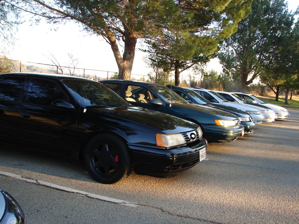 Several sedans parked in a row, with the closest one being black