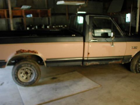 1988 Ford F-150 - This 1988 Ford F-150 pickup truck has rust on the rear fender and is parked indoors.