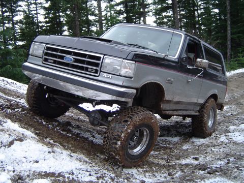 1989 Ford Bronco - This lifted 1989 Ford Bronco navigates a challenging snowy and muddy terrain.