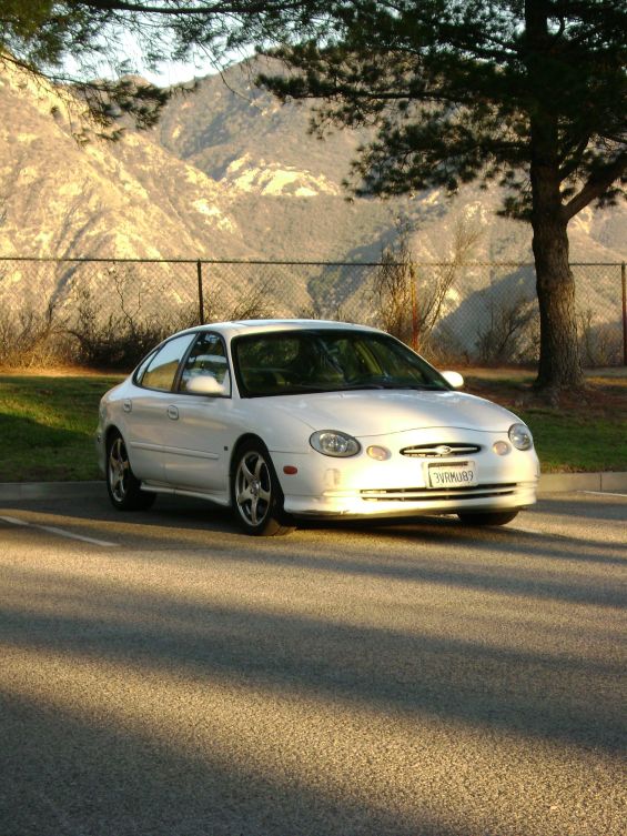 White sedan parked outdoors, front 3/4 view. License plate WRM683