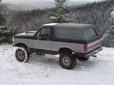 1989 Ford Bronco - Lifted 1989 Ford Bronco in a snowy forest landscape.