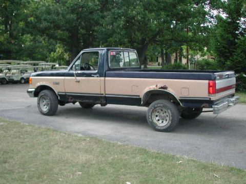 1988 Ford F-150 - This two-tone 1988 Ford F-150 pickup truck is shown from the side.