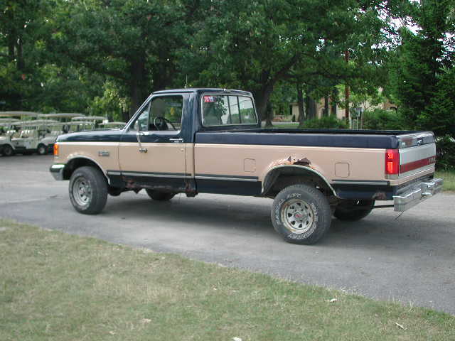 Side view of a 1988 Ford F-150 pickup truck in tan and blue