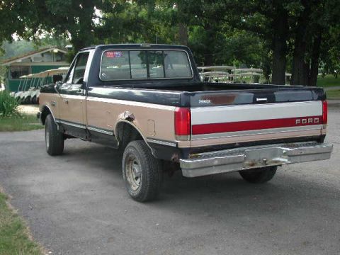 1988 Ford F-150 - Two-tone Ford F-150 pickup truck with a red and white stripe on the tailgate.