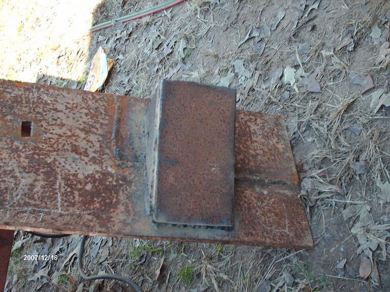 Rusty metal bracket with square hole and welded block