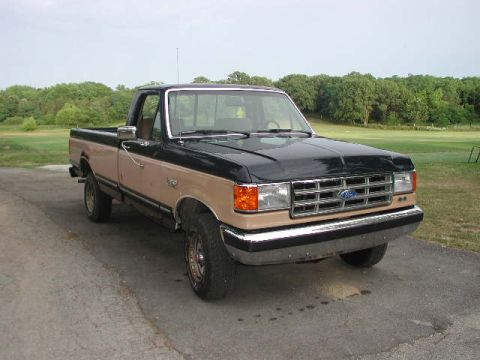 1988 Ford F-150 - This two-tone Ford F-Series pickup truck is parked outdoors on a cloudy day.