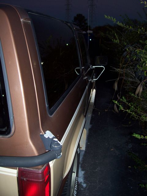 1984 Ford Bronco II - Side profile of a brown SUV, showing its tinted windows and chrome side mirror.