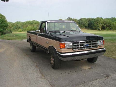 1988 Ford F-150 - This two-tone Ford F-150 pickup truck is seen from the front-right angle, parked outdoors.
