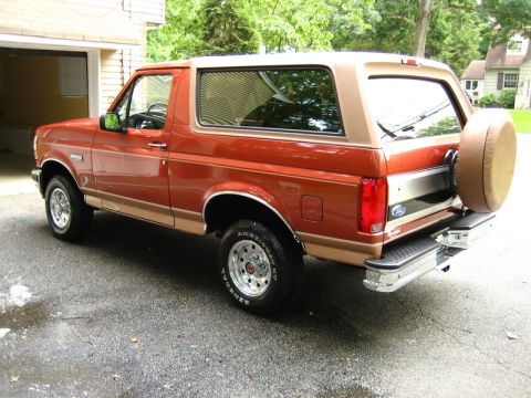 1992 Ford F-150 - This 1992 Ford Bronco is parked outside a garage with a spare tire on the back.