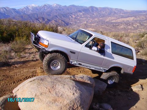 1990 Ford Bronco - Silver Ford Bronco navigating rocky terrain off-road.