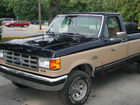 1988 Ford F-150 - This two-tone 1987 Ford F-150 pickup truck is shown from the front three-quarter view.