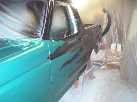 1987 Ford Bronco - Car door undergoing painting with protective plastic sheeting in place.