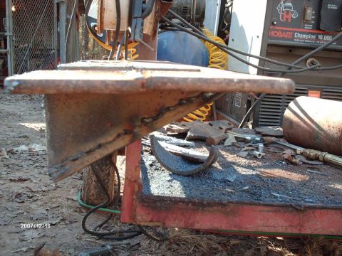 1990 Ford F-150 - A close-up view of a metal bracket being welded, with a Hobart Champion 10,000 welding machine visible in the background.