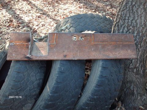 1990 Ford F-150 - Custom metal bracket sits on old tires, likely for a vehicle modification project.