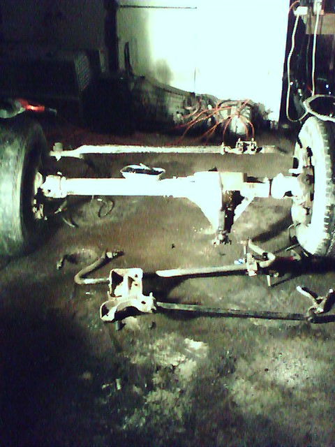 1992 Ford Bronco - Vehicle axle and suspension parts are laid out on a workshop floor.