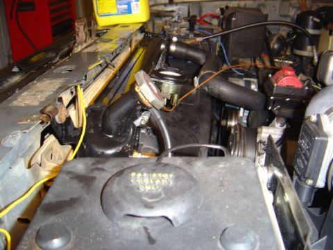 1986 Ford Bronco - The engine bay shows the radiator and associated hoses. A cap is marked for coolant use only.