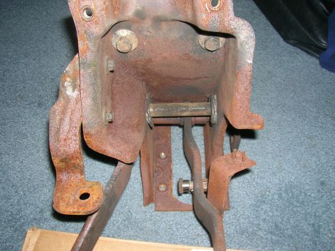 1979 Ford Bronco - Close-up of a heavily rusted clutch pedal assembly, likely from an older vehicle.