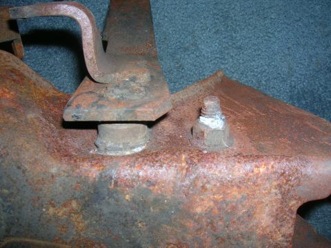 1979 Ford Bronco - Close-up of heavily rusted metal bracket with a bolt and nut visible.