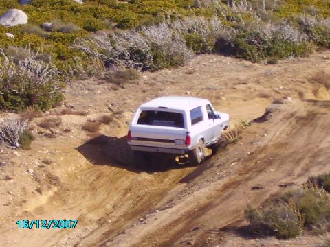 1990 Ford Bronco - 1990 Ford Bronco navigates a challenging off-road trail.