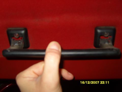 1989 Ford Bronco - A hand grips a black grab handle mounted on a red surface, with a timestamp in the corner.