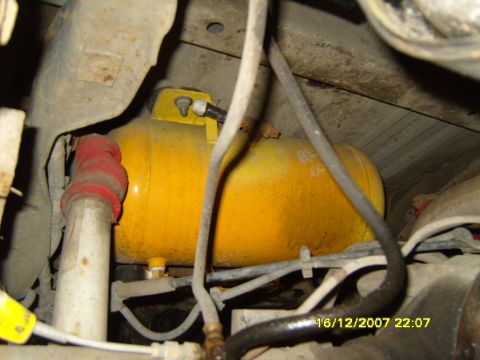 1989 Ford Bronco - Undercarriage view of a yellow air compressor tank and suspension components.