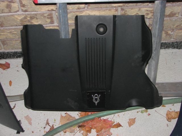 Black engine cover with V8 emblem and vertical lines