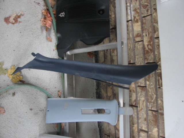 Car interior trim pieces laid out on the ground and leaning against a wall