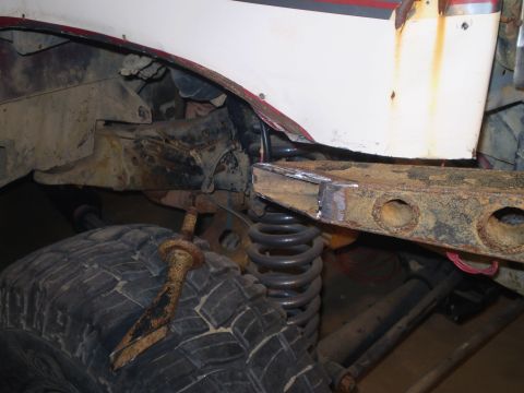 1986 Ford Bronco - The image shows a close-up of a vehicle's undercarriage, focusing on the frame and suspension components.