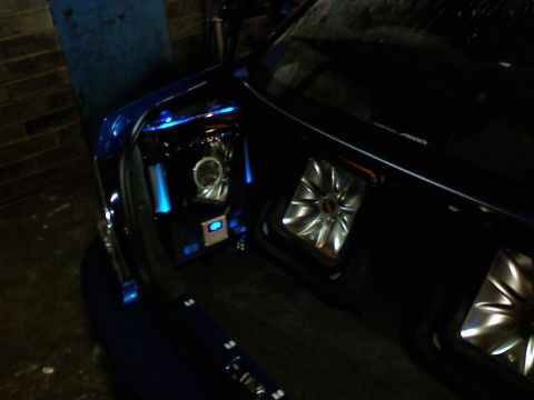 2007 Subaru Impreza - The trunk of a blue car is fitted with a custom audio system multiple speakers and LED lighting.