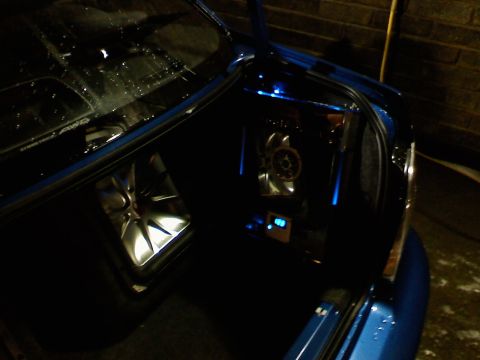 2007 Subaru Impreza - The trunk of a blue car is open, revealing a subwoofer and amplifier with blue LED lighting.