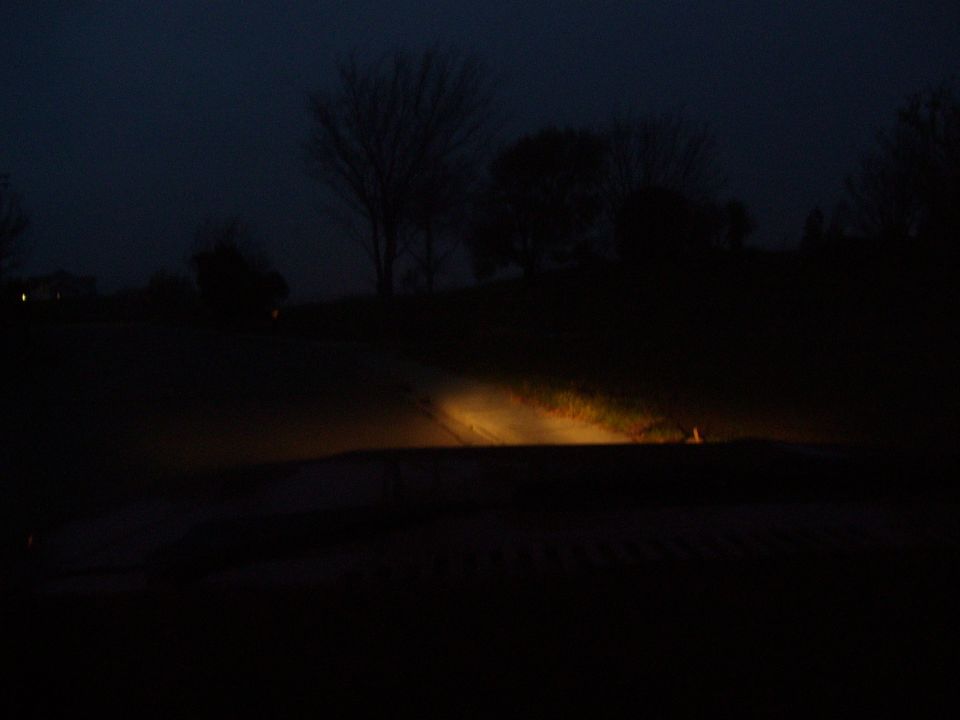 Headlights on a dark road at night