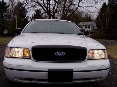 1999 Ford Crown Victoria - Front view of a white 1999 Ford Crown Victoria, its black grille and headlights.