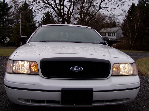 White 1999 Ford Crown Victoria front view with black grille and Ford logo
