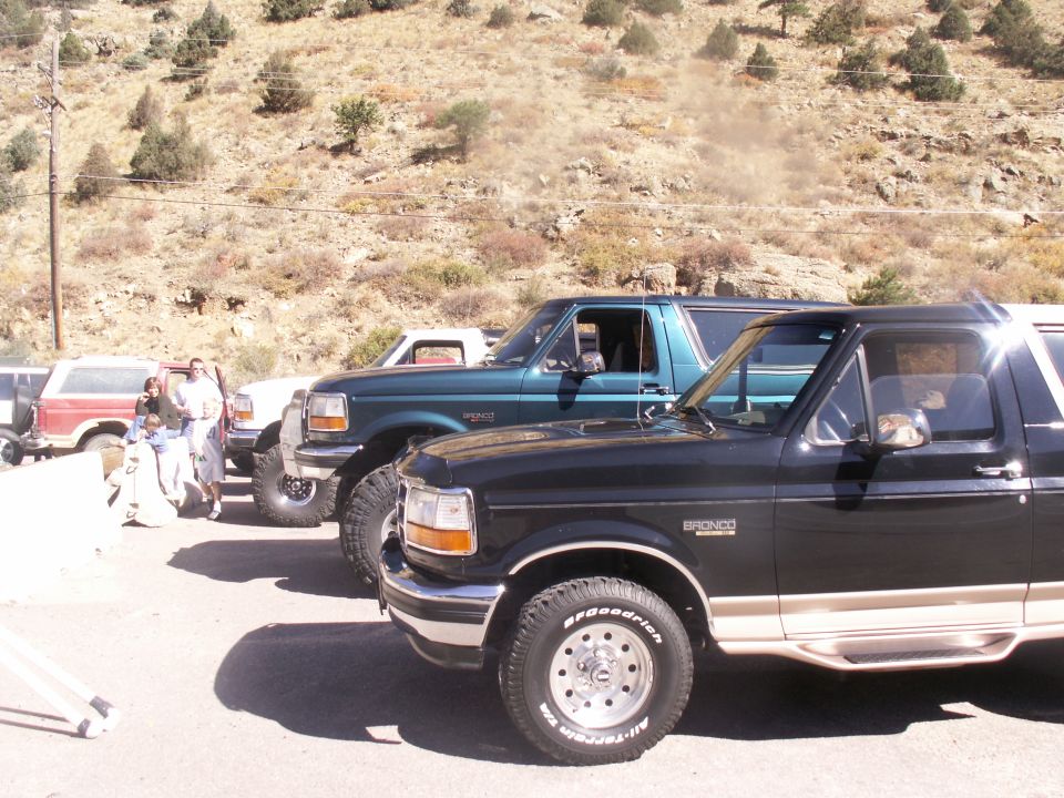 Black Ford Bronco with tan trim, side view, showing front fender, door, and rear quarter panel