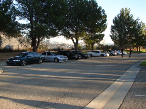 1992 Ford Taurus - A parking lot scene multiple cars and trees, with two people standing in the distance.
