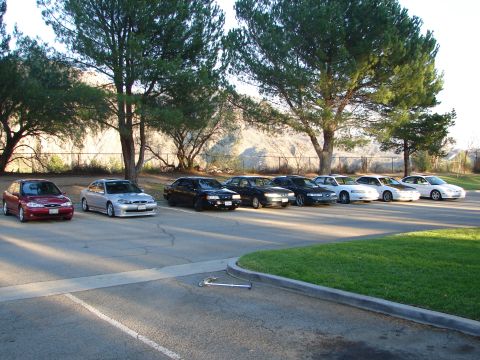 1992 Ford Taurus - A row of cars are parked in a lot during the day.