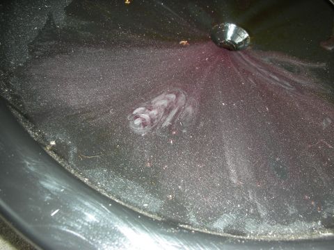 1992 Ford Crown Victoria - Close-up of a transmission pan showing fluid residue and swirling patterns.