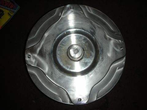 1992 Ford Crown Victoria - A metal torque converter is shown, a central hub and distinctive wavy fins around its perimeter.
