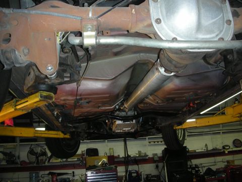 1992 Ford Crown Victoria - The underside of a vehicle is viewed from below, revealing its transmission and exhaust components.