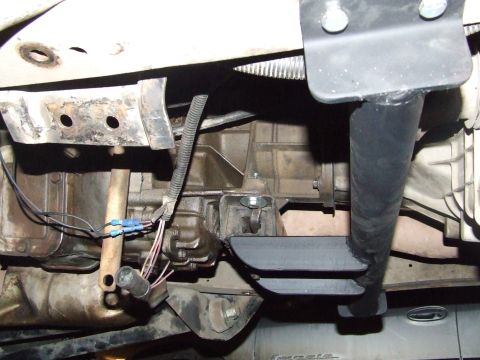 1990 Ford Bronco - Close-up view of the undercarriage, focusing on the transmission and exhaust system components.